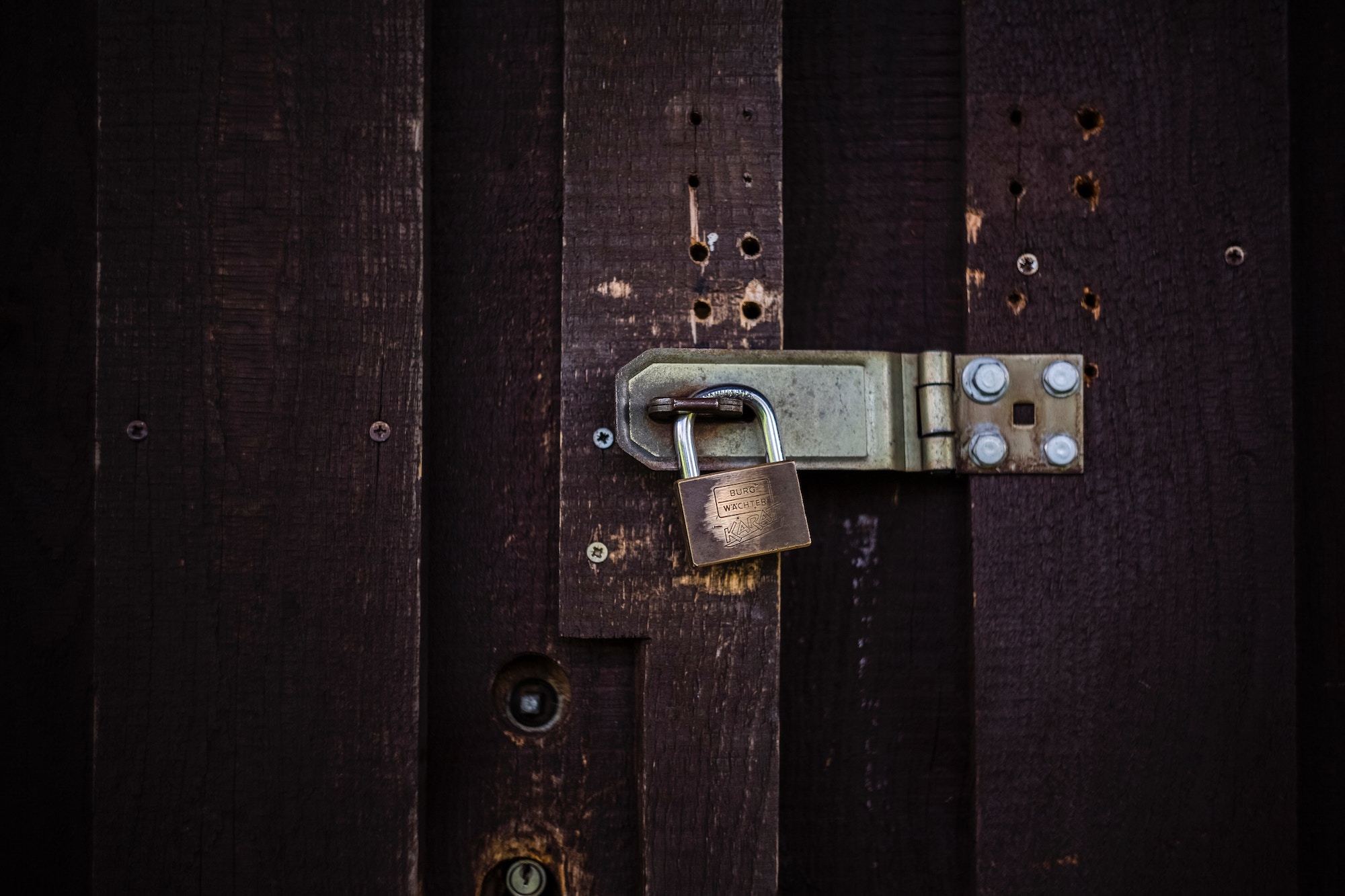 padlock on a brown fence